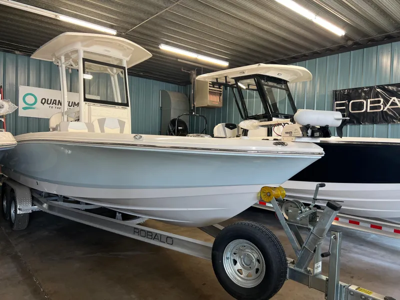 Slide: The Image of 2023 Robalo 246 Cayman boat on trailer in showroom. - 2