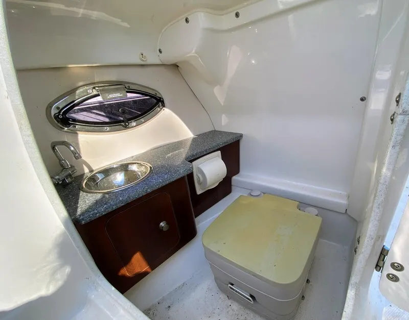 Slide: The Image of 2016 Chaparral 224 Sunesta boat interior bathroom with sink and portable toilet. - 17