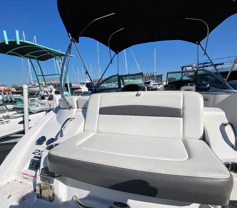 Slide: The Image of 2016 Chaparral 224 Sunesta boat with cushioned seating and canopy at marina. - 26