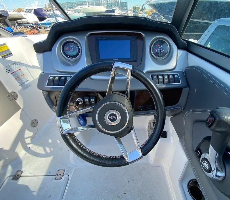 Slide: The Image of 2016 Chaparral 224 Sunesta boat dashboard with steering wheel and control panel. - 6