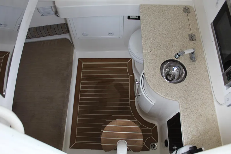 Slide: The Image of Interior of 2014 Regulator 34 SS boat with sink, toilet, and wooden flooring. - 15