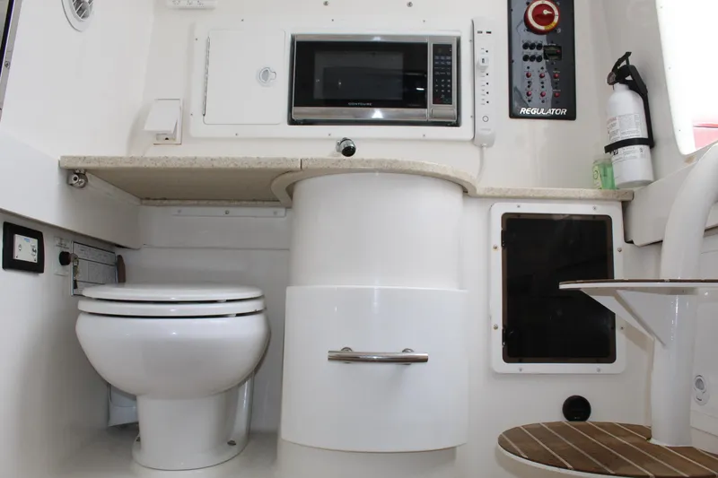 Slide: The Image of Interior of 2014 Regulator 34 SS boat featuring a toilet, microwave, and control panel. - 17