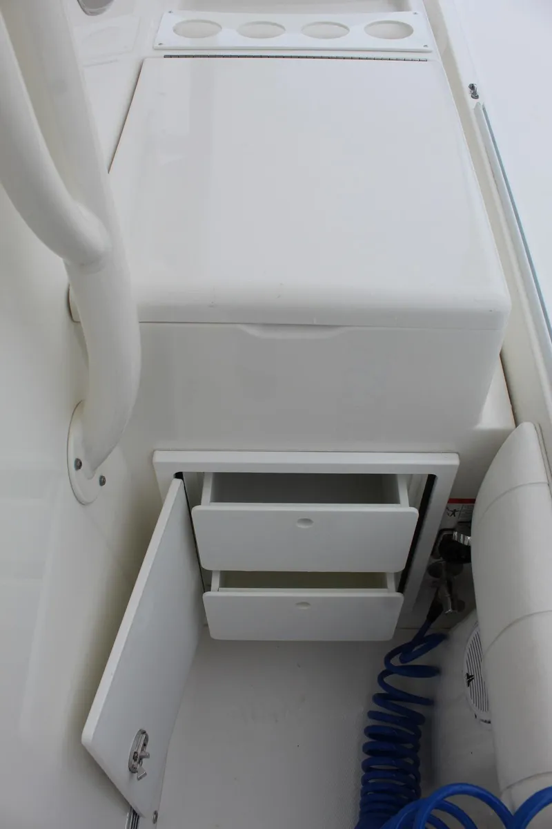 Slide: The Image of 2014 Regulator 34 SS boat storage compartment with open drawers and cup holders. - 26