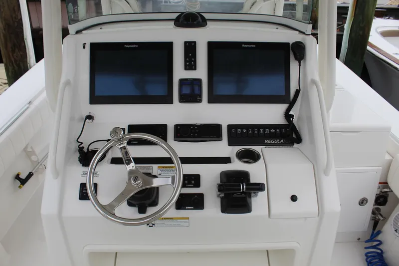 Slide: The Image of 2014 Regulator 34 SS boat dashboard with dual Raymarine displays and Yamaha controls. - 27