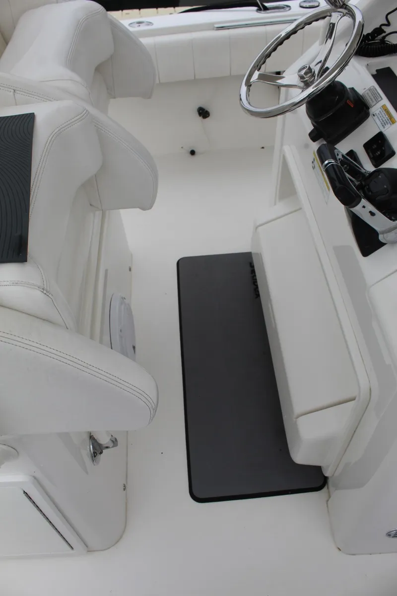 Slide: The Image of 2014 Regulator 34 SS boat cockpit with white seating and steering wheel. - 29