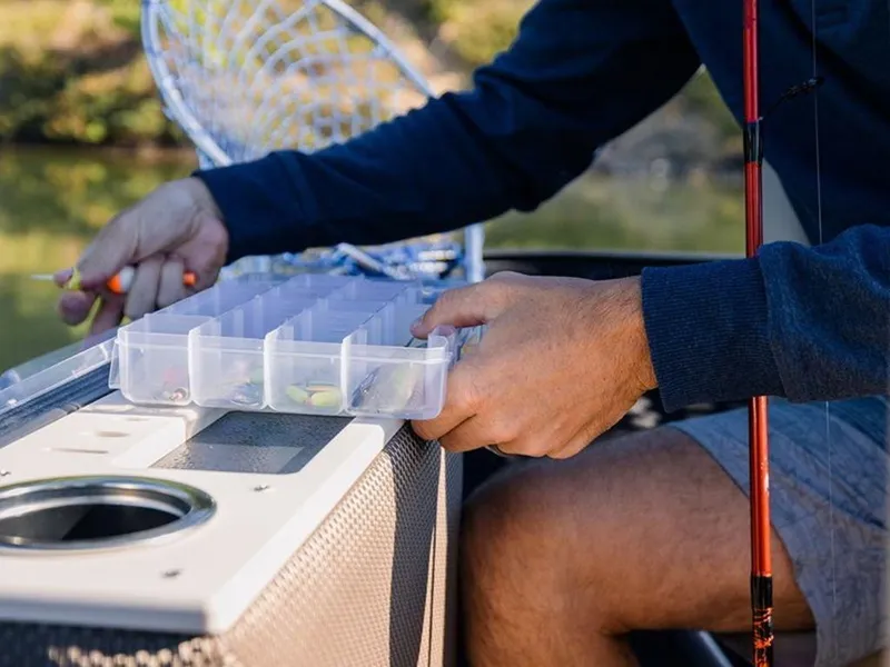 Slide: The Image of Man organizing fishing tackle on a 2023 Crest Classic LX 240 SLRC CPT boat. - 4