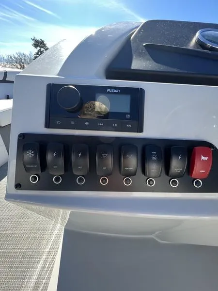 Slide: The Image of Control panel of 2023 Crest Classic LX 220 SLC boat with switches and a Fusion stereo. - 10