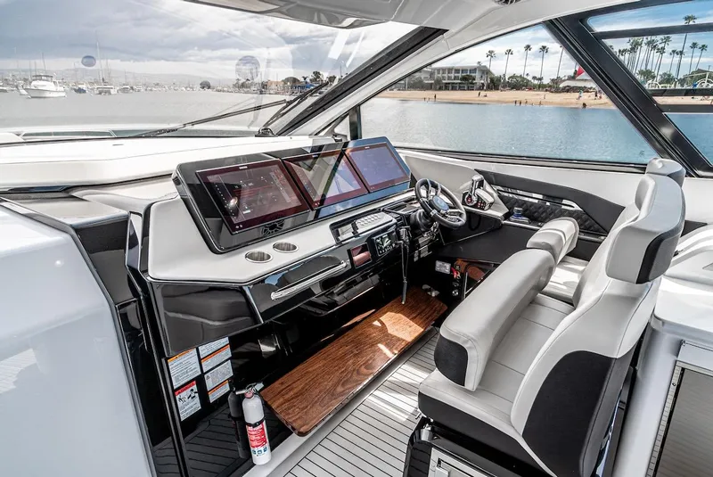Slide: The Image of 2024 Cruisers Yachts 50 GLS helm station with modern navigation displays and luxurious seating. - 44