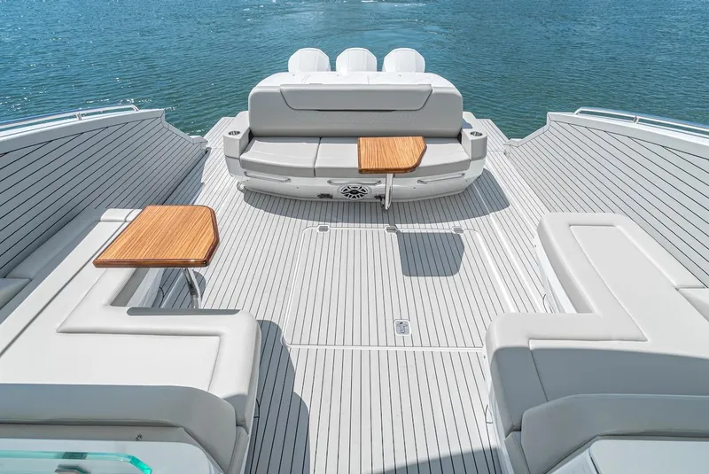 Slide: The Image of 2024 Cruisers Yachts 50 GLS deck with seating and tables on the water. - 25