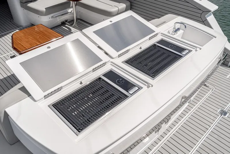 Slide: The Image of Outdoor kitchen on the 2024 Cruisers Yachts 50 GLS with dual grills and sink. - 28