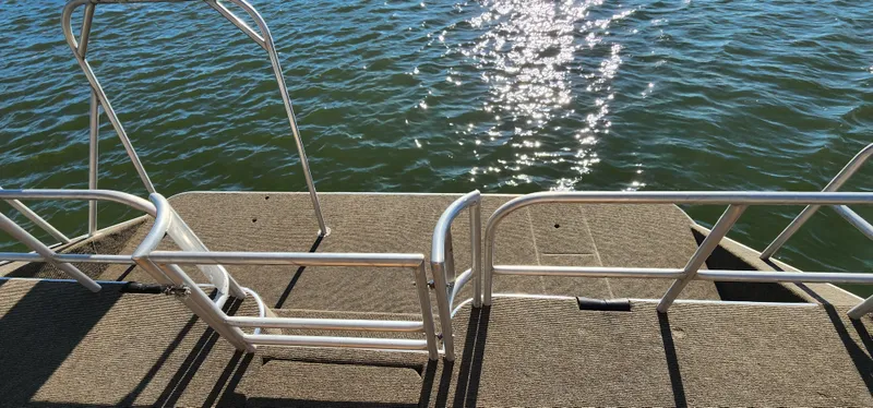 Slide: The Image of Sunstar 16x78 houseboat deck with metal railings overlooking water, 1996 model. - 16