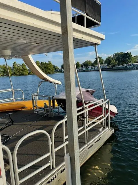 Slide: The Image of 1996 Sunstar 16x78 houseboat docked on a serene lake. - 17