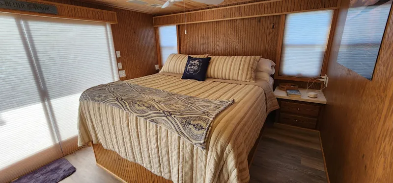 Slide: The Image of Cozy bedroom in a 1996 Sunstar 16x78 houseboat with wood paneling and large bed. - 26