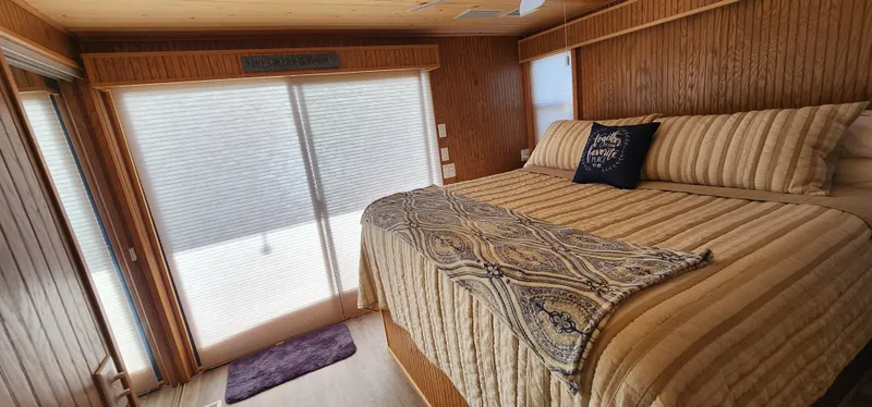 Slide: The Image of Cozy bedroom in a 1996 Sunstar 16x78 houseboat with wooden walls and large bed. - 27