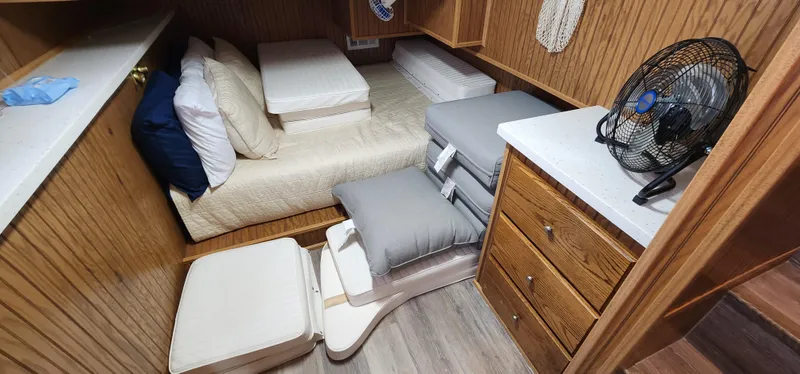 Slide: The Image of Small bedroom in a 1996 Sunstar 16x78 houseboat with wooden cabinets and a fan. - 31
