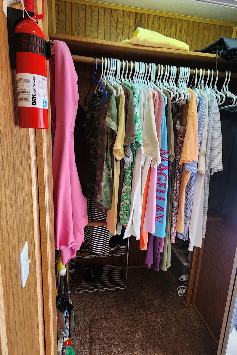 Slide: The Image of Closet in a 1996 Sunstar 16x78 houseboat with hanging clothes and a fire extinguisher. - 34
