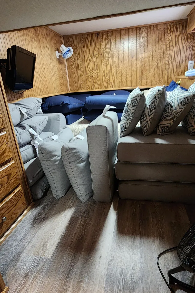 Slide: The Image of Interior of 1996 Sunstar 16x78 houseboat with stacked cushions and wooden paneling. - 40