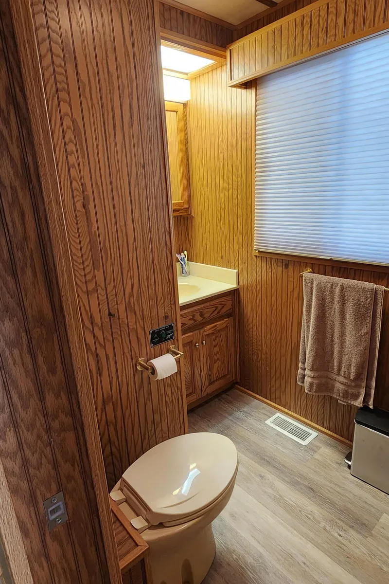 Slide: The Image of 1996 Sunstar 16x78 houseboat bathroom with wood paneling and modern fixtures. - 48