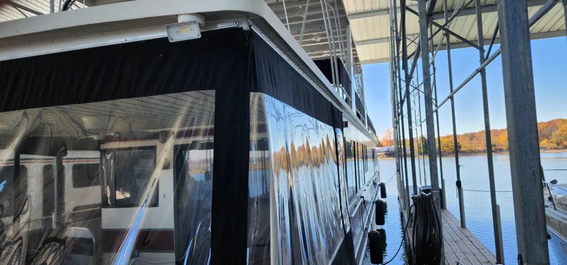 Slide: The Image of 1996 Sunstar 16x78 houseboat docked under a covered marina. - 9