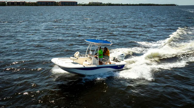Slide: The Image of 2022 Carolina Skiff 21 LS boat cruising on open water, creating a wake. - 1
