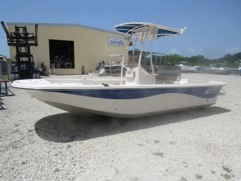 Slide: The Image of 2022 Carolina Skiff 21 LS boat with blue accents, parked outdoors on gravel. - 5
