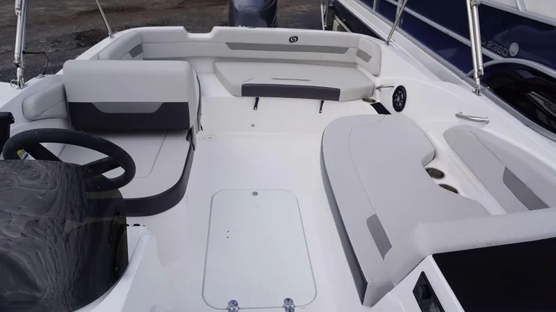 Slide: The Image of 2023 Hurricane 185 SS boat interior with white and gray seating, steering wheel, and storage compartments. - 16