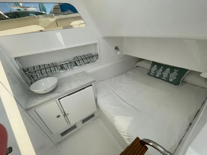 Slide: The Image of 2025 Mag Bay 43 Center Console cabin with bed, sink, and storage. - 26