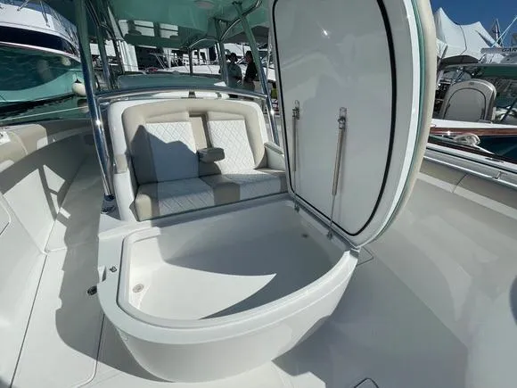 Slide: The Image of 2025 Mag Bay 43 Center Console boat with open storage compartment and cushioned seating. - 45