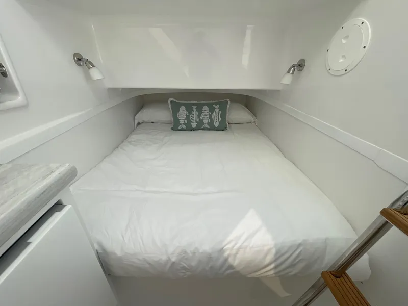 Slide: The Image of 2025 Mag Bay 43 Center Console cabin with a cozy bed and modern lighting. - 27