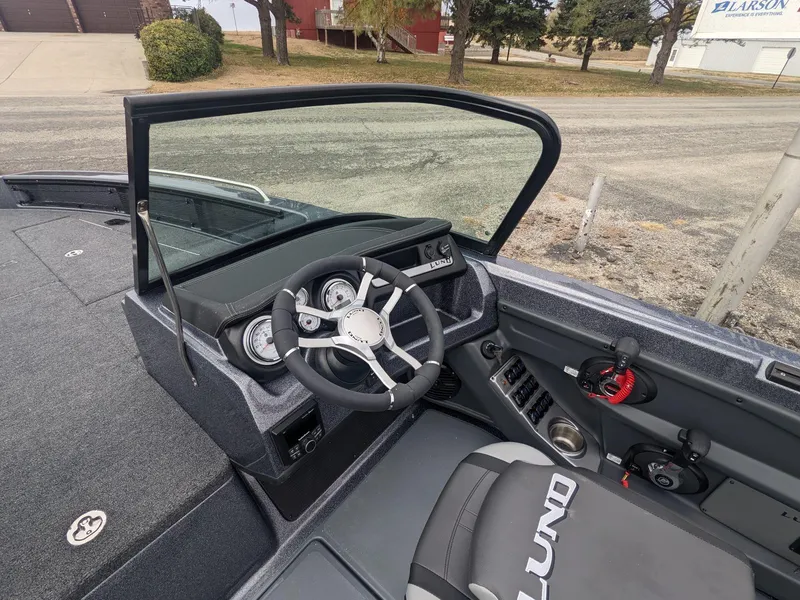 Slide: The Image of 2025 Lund 219 Pro V Fiberglass boat interior with steering wheel and dashboard. - 11