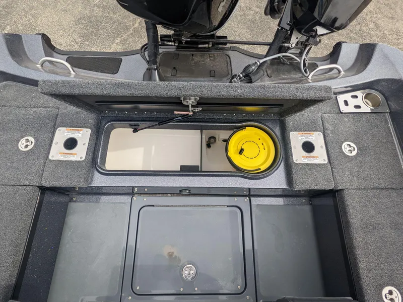 Slide: The Image of 2025 Lund 219 Pro V Fiberglass boat interior with storage compartments and fishing equipment. - 16