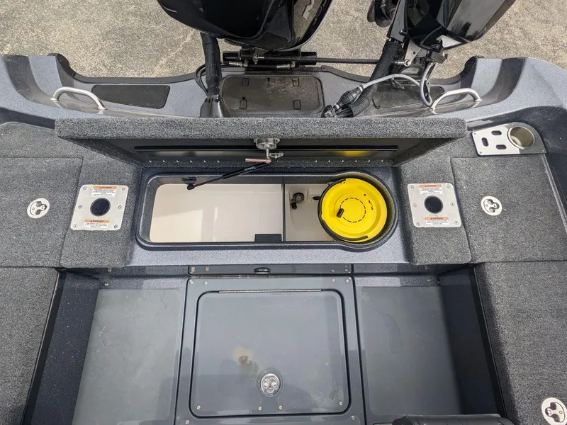 Slide: The Image of 2025 Lund 219 Pro V Fiberglass boat interior with storage compartments and fishing rod holders. - 17