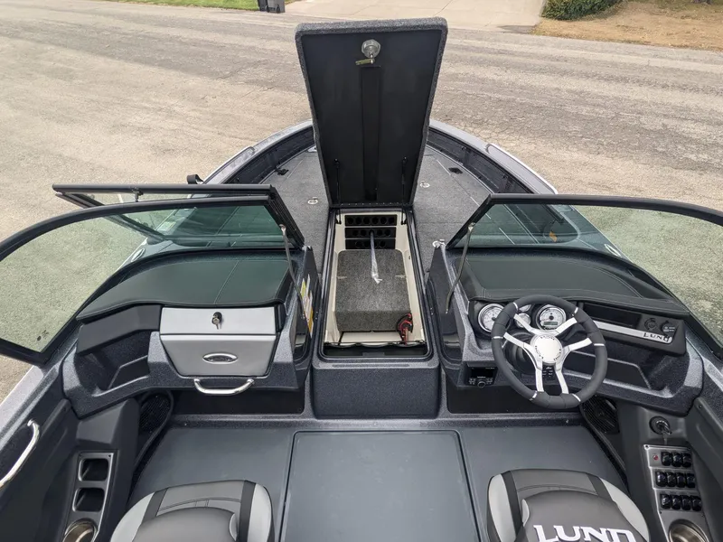 Slide: The Image of 2025 Lund 219 Pro V Fiberglass boat interior with open storage compartments. - 3