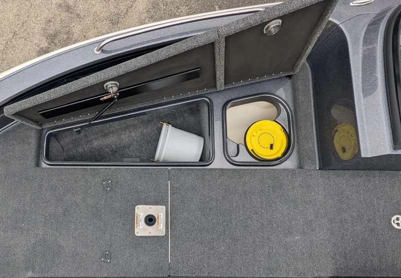 Slide: The Image of 2025 Lund 219 Pro V Fiberglass boat storage compartments with bucket and yellow lid. - 7