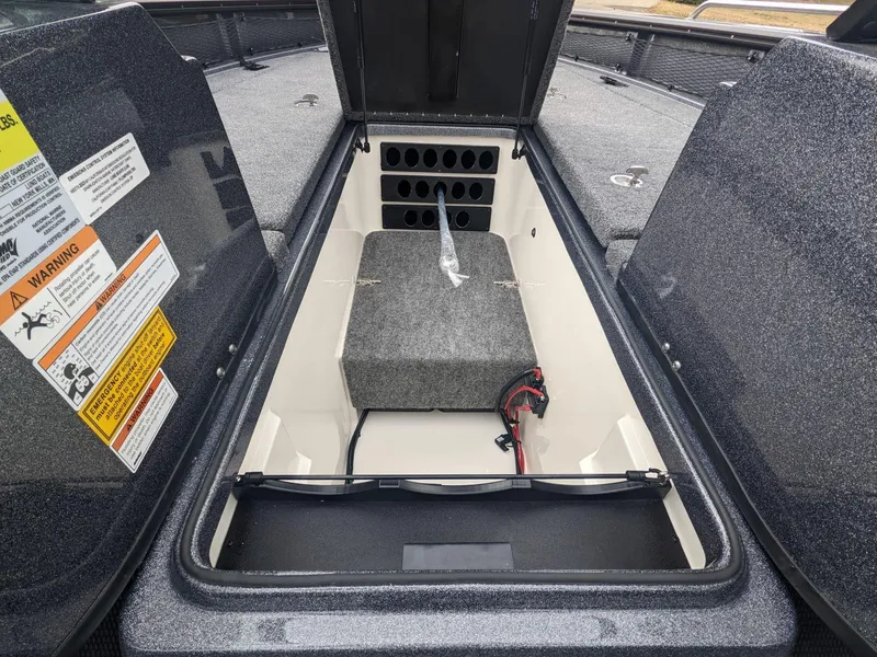 Slide: The Image of 2025 Lund 219 Pro V Fiberglass boat storage compartment with safety warnings. - 8