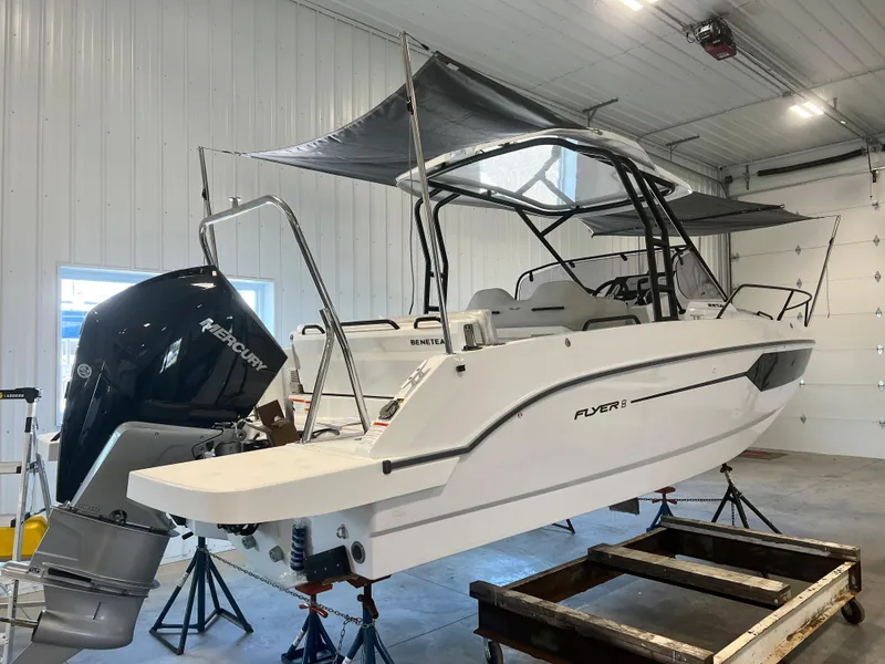 Slide: The Image of 2024 Beneteau Flyer 8 SUNdeck boat in indoor storage with Mercury outboard motor. - 2