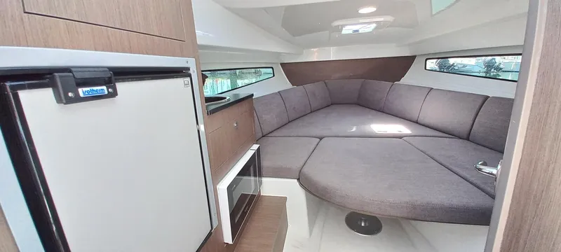 Slide: The Image of 2024 Beneteau Flyer 8 SUNdeck interior with cozy seating and compact kitchenette. - 23