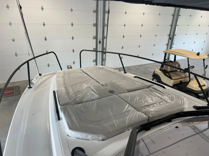 Slide: The Image of 2024 Beneteau Flyer 8 SUNdeck boat in a garage with a golf cart nearby. - 5