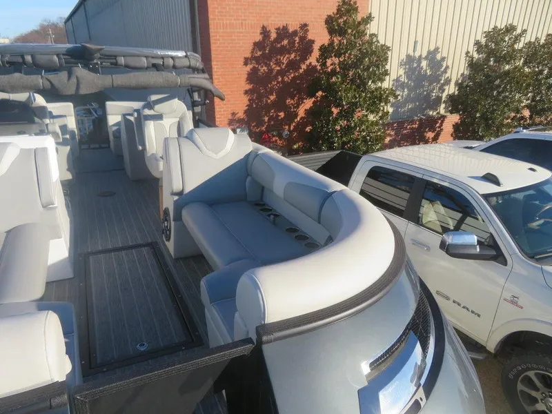 Slide: The Image of 2023 Montara SURF BOSS MT2.0 25 boat interior with seating and a white truck nearby. - 5