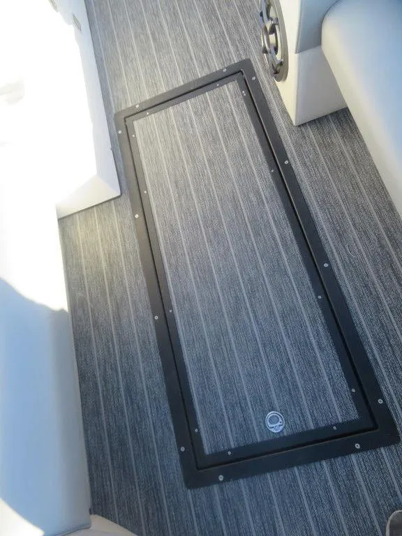 Slide: The Image of 2023 Montara SURF BOSS MT2.0 25 boat interior with gray flooring and storage hatch. - 9