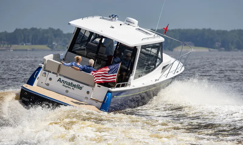 Slide: The Image of MJM 42 boat cruising on water, 2025 model, with American flag. - 12