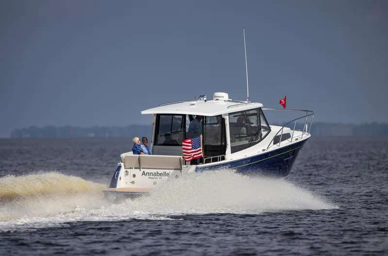 Slide: The Image of 2025 MJM 42 boat cruising on open water with American flag. - 13