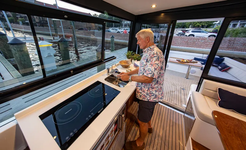 Slide: The Image of Man cooking in modern kitchen on 2025 MJM 42 yacht by the dock. - 19