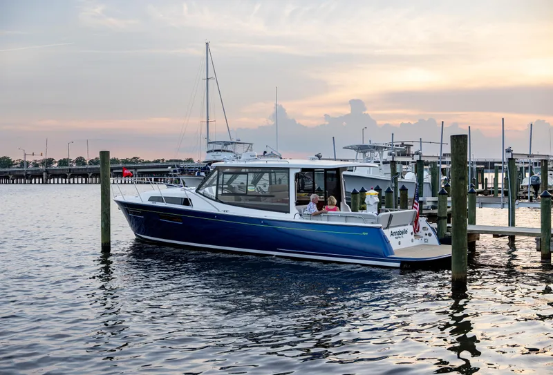Slide: The Image of 2025 MJM 42 boat docked at sunset, calm waters, marina background. - 27