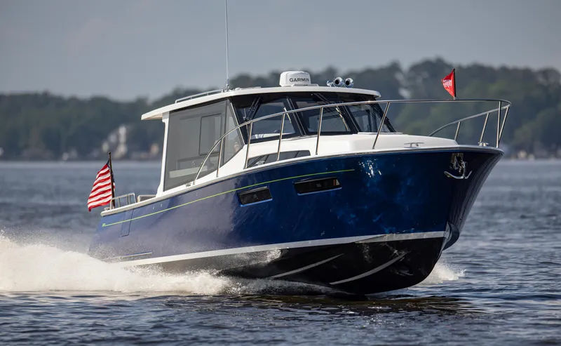 Slide: The Image of 2025 MJM 42 boat cruising on a lake with American flag. - 3