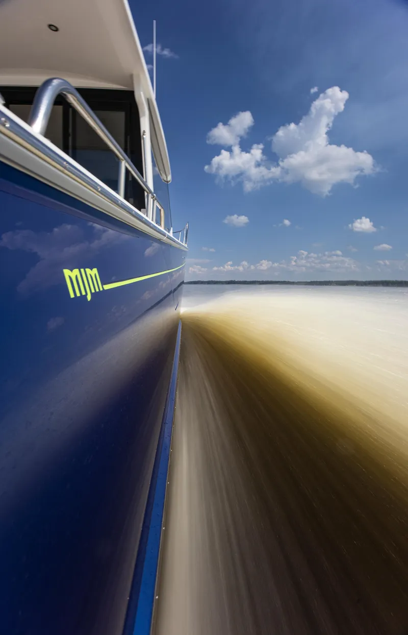 Slide: The Image of 2025 MJM 42 boat cruising on open water under a clear blue sky. - 30