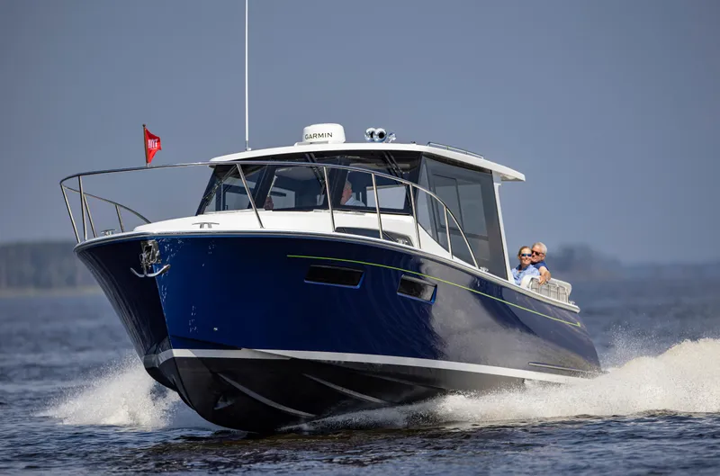 Slide: The Image of 2025 MJM 42 boat cruising on open water with passengers enjoying the ride. - 5