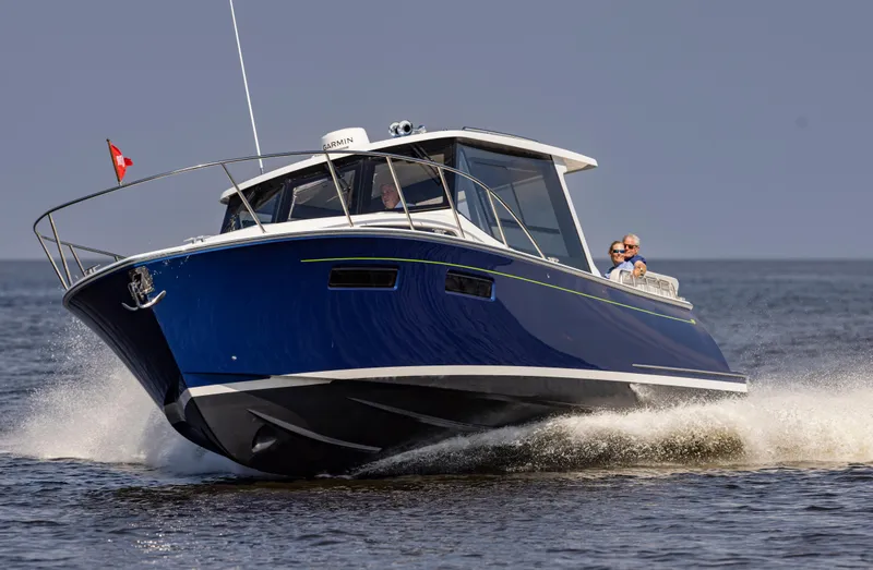 Slide: The Image of 2025 MJM 42 boat cruising on open water, featuring sleek blue design. - 6