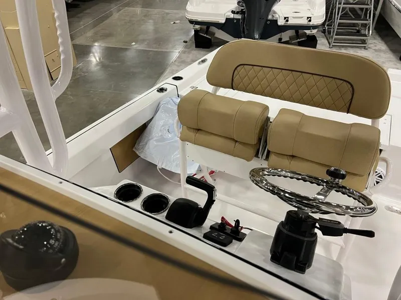 Slide: The Image of 2023 Sportsman 227 MASTERS boat interior with tan seating and steering wheel. - 16