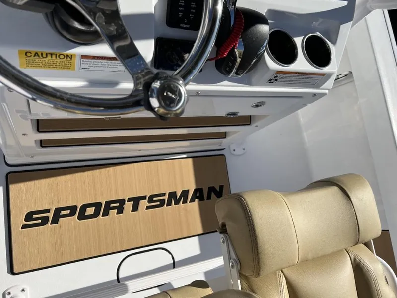 Slide: The Image of 2023 Sportsman 227 Masters boat interior with steering wheel and beige seating. - 7